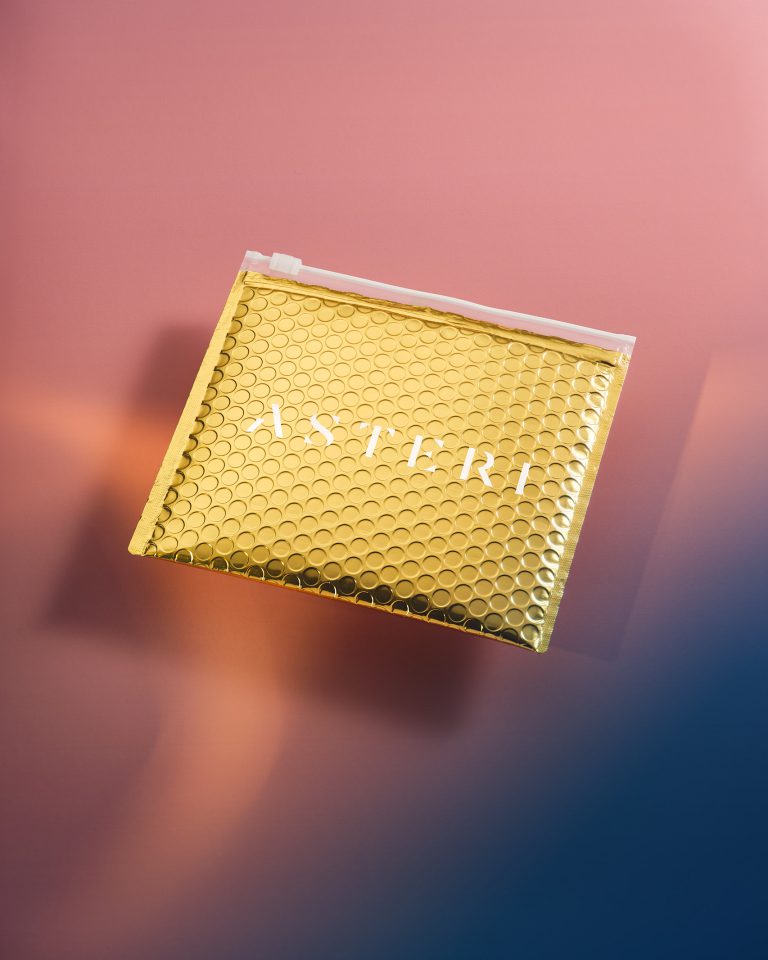 Asteri cosmetic packaging on pink and blue gradient background, studio still life