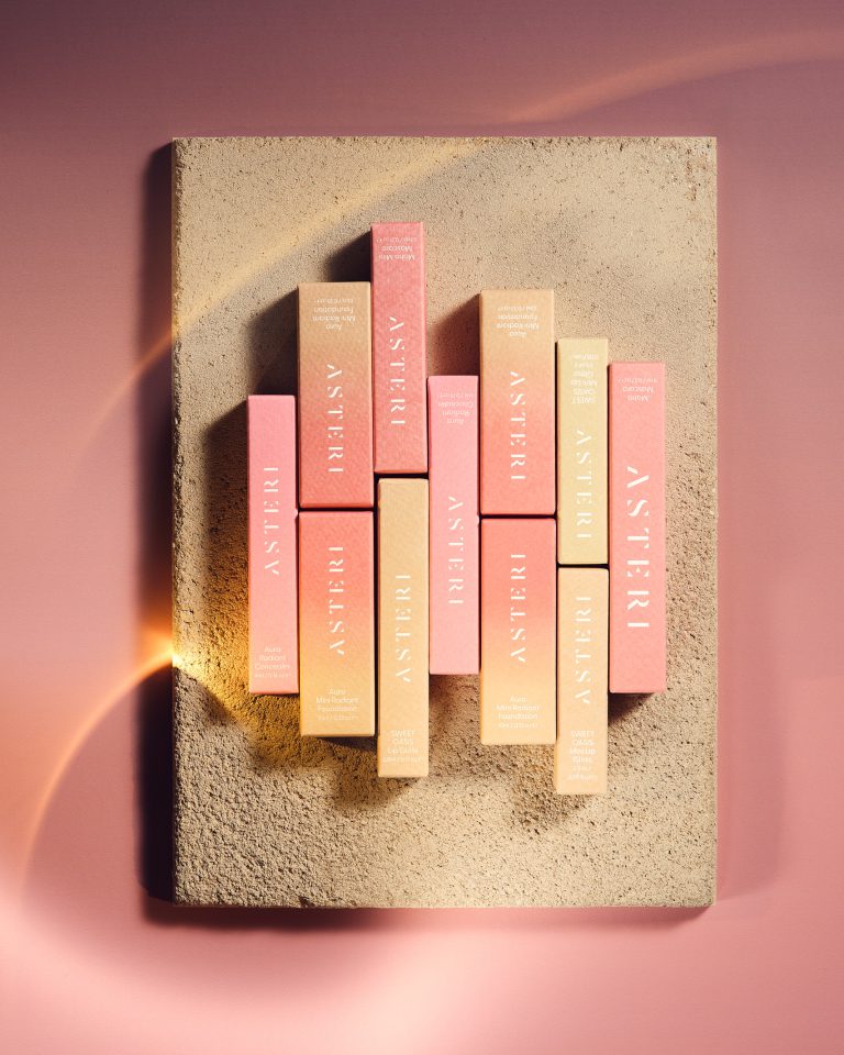 Asteri lip products arranged in sculptural formation on textured surface