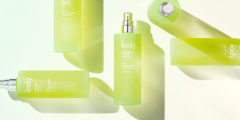 Ilody green skincare bottle in layered composition with reflective highlights