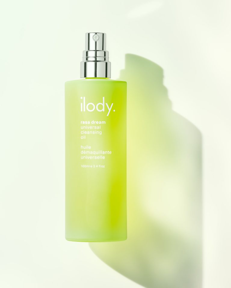 Ilody green skincare bottle with soft shadow on pale background, studio still life