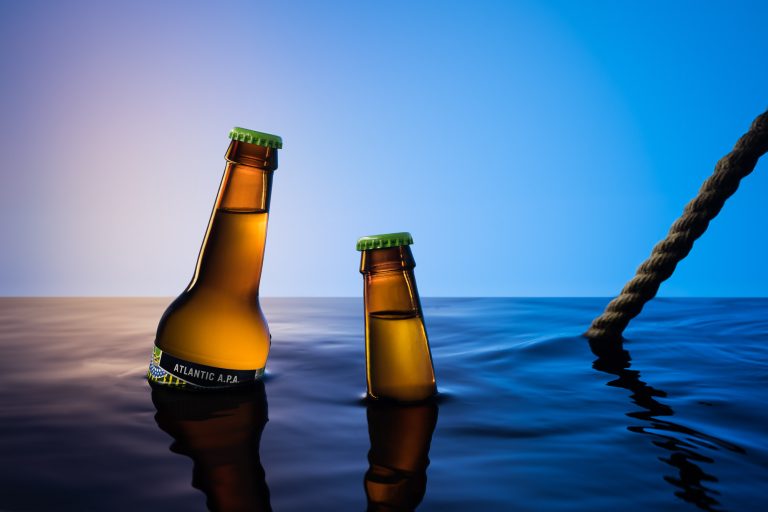 Brixton beer bottles in water tank studio setup with blue gradient lighting