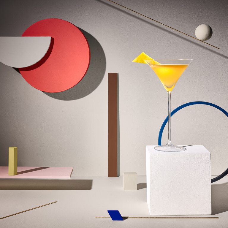 Yellow cocktail on sculptural geometric set with bold shapes and shadows