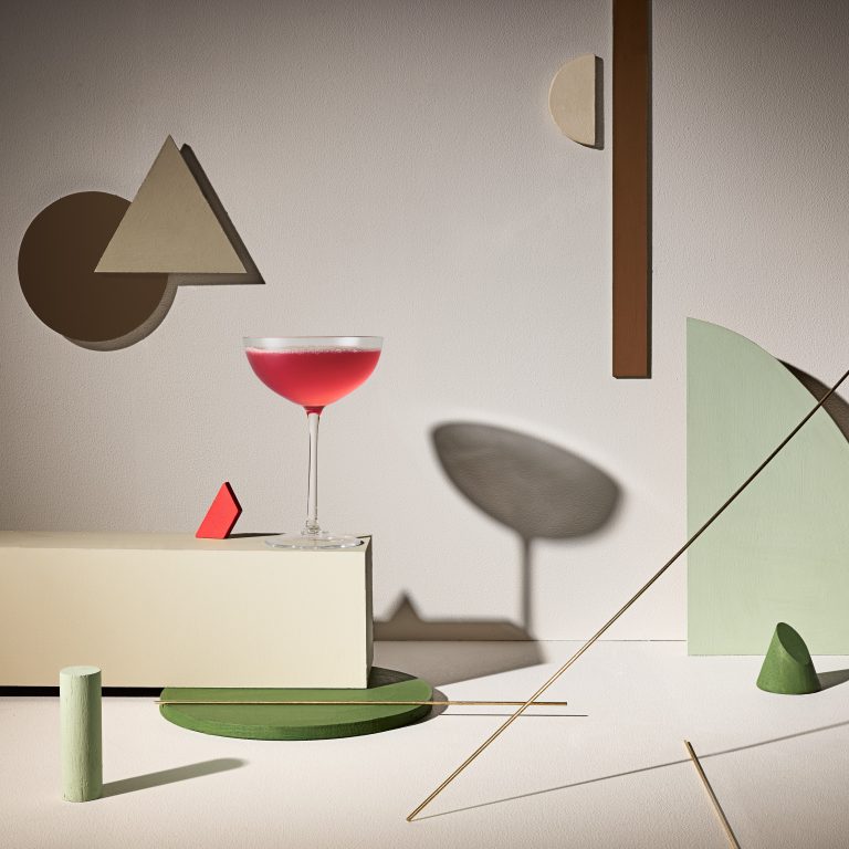 Cocktail glass on geometric Bauhaus-inspired set with abstract shapes
