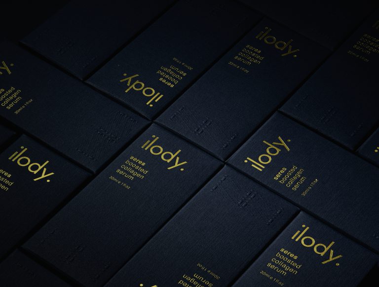 Close-up of Ilody navy packaging with gold typography in low light