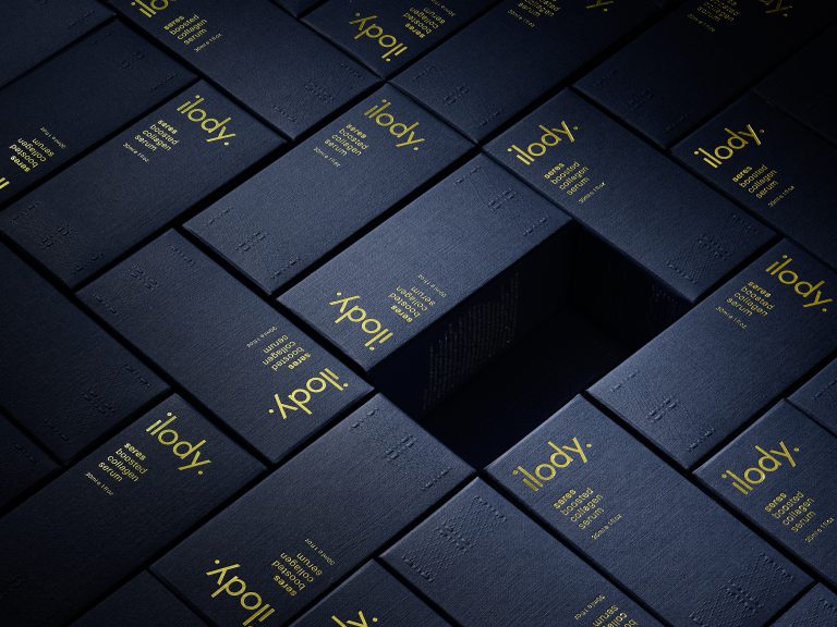 Ilody cobalt skincare boxes arranged in geometric layered formation with gold branding