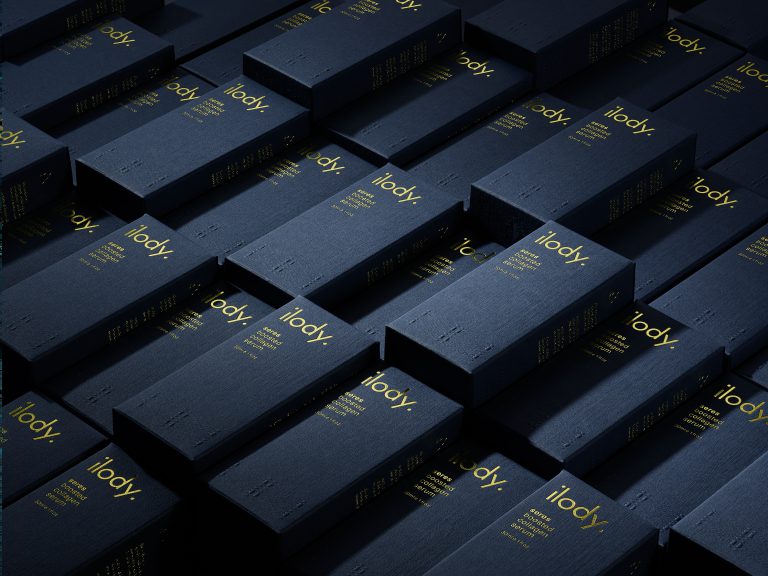 Stacked Ilody cobalt skincare boxes in structured studio arrangement