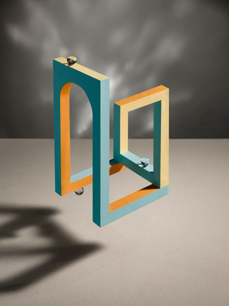 Interlocking geometric frames in blue and orange forming architectural illusion, studio still life