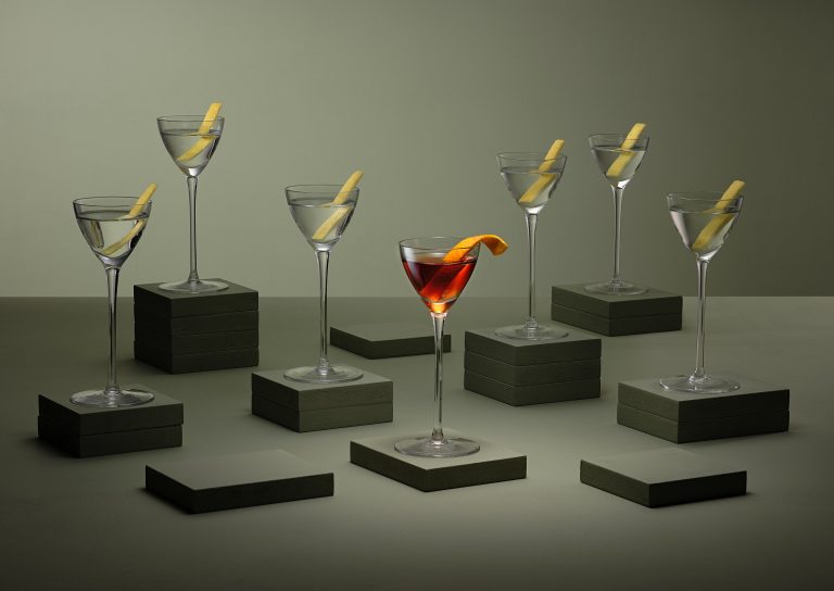 Multiple cocktail glasses on plinths in studio setting, editorial drinks photography