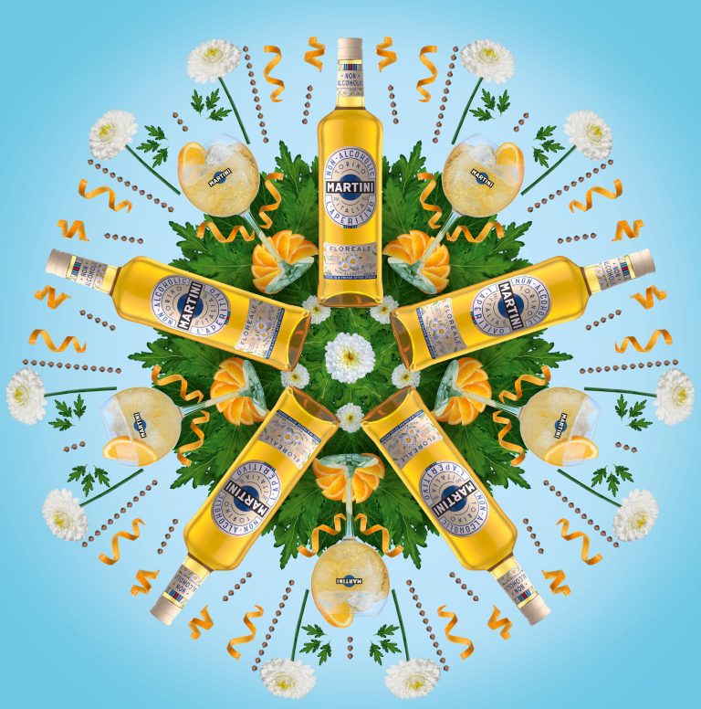 Martini bottle centred in radial botanical arrangement on blue backdrop