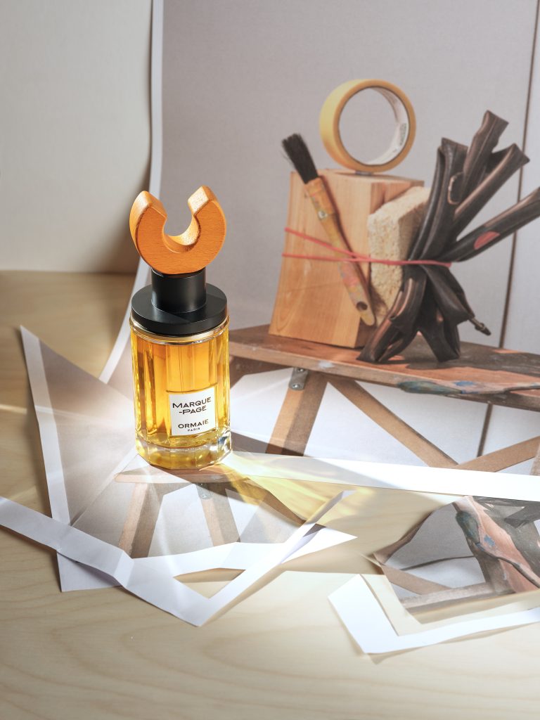 ORMAIE Perfume bottle with geometric wooden forms and orange sculptural element in studio still life