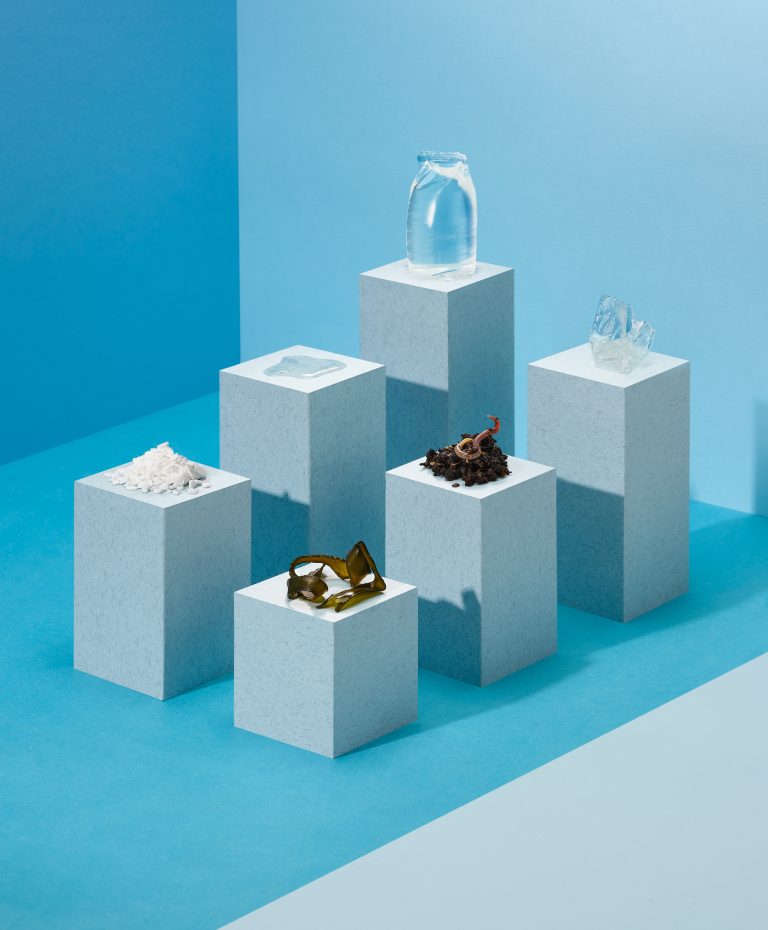 Ooho edible water packaging displayed on white plinths against blue background