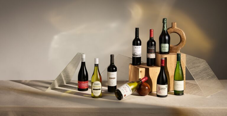 Selection of wine bottles arranged on neutral sculptural plinths, studio lighting