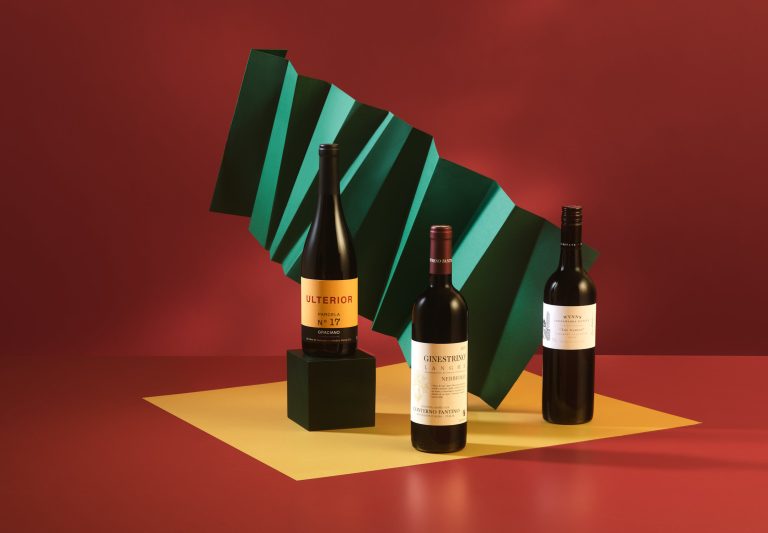 Wine bottles on red and yellow set with green geometric backdrop