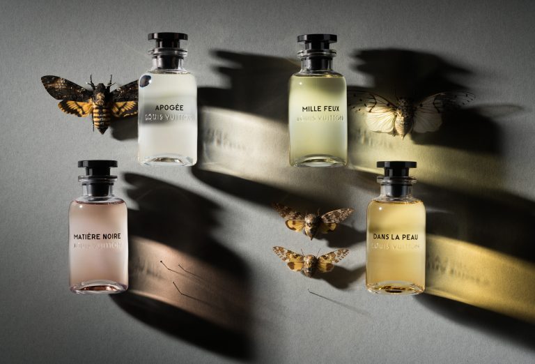 Louis Vuitton perfume bottles arranged in layered composition with dramatic shadows