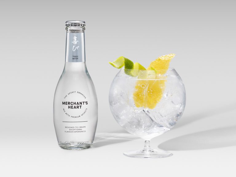 Merchant’s Heart tonic bottle with citrus garnish in coupe glass, product photography
