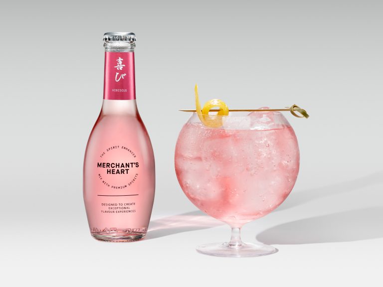 Merchant’s Heart pink bottle with large goblet cocktail and citrus garnish