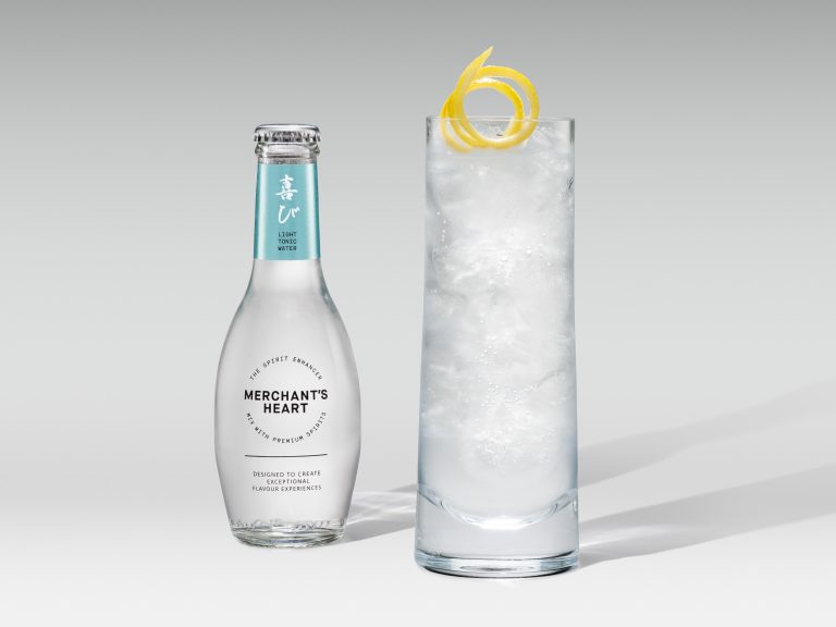 Merchant’s Heart tonic bottle with tall iced highball and lemon twist